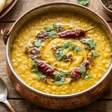 Golden lentil dhal in a terracotta bowl