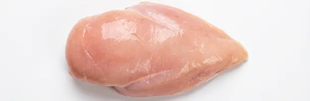 Raw chicken breast on a wooden cutting board